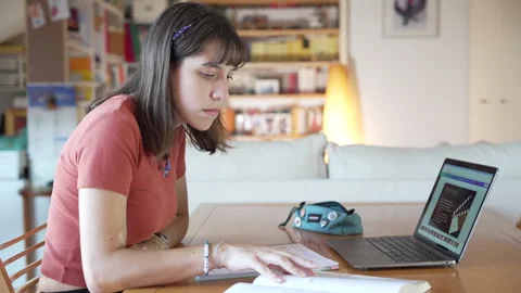 Girl studies and does homework at desk at home Stock Footage 285135650