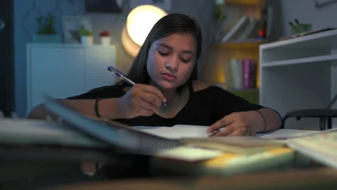 Girl studying and writing notes in notebook at home late night Stock Footage 228100393