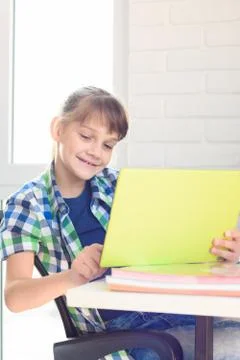 Girl studying in a tablet computer while sitting at a table at home Stock Photos