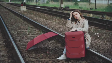 Girl with a suitcase waiting for a train on the railway Stock Footage 132275053