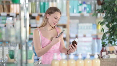 Girl in summer clothes scans code on cough syrup to check the expiration date Stock Footage 316114291