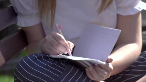 Girl in summer making notes in a paper notebook Stock Footage 280682937