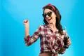 The girl in sunglasses standing with a bottle of drink on the blue background Photo