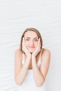 A girl with surprised expression while touching her face with her hands. 库存照片