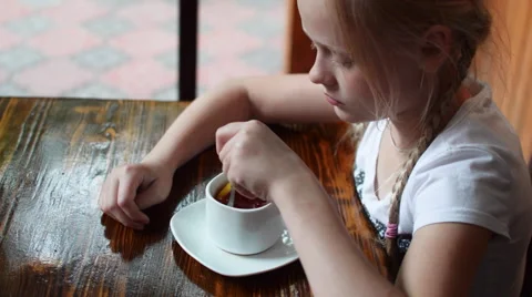 Girl at the Table Drinking Tea Stock Footage 64324609