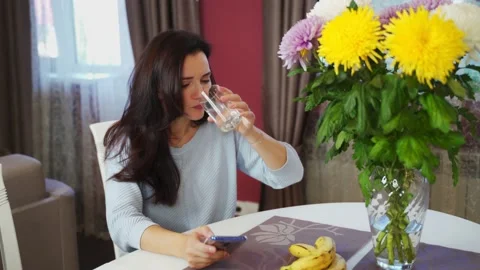 The girl at the table drinks cold water and her toothache begins to hurt Stock Footage 141540103