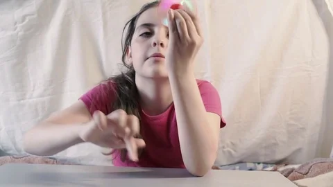 Girl at the table playing a toy Stock Footage 76860148
