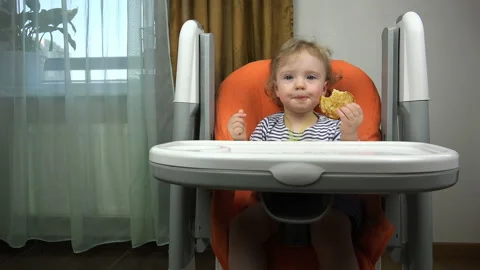 The girl at the table talking to the camera and waving a cake Stock Footage 96404698