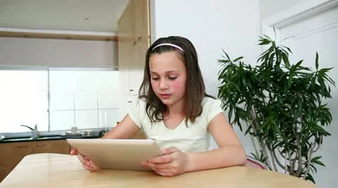 Girl with a tablet computer in the kitchen Stock Footage