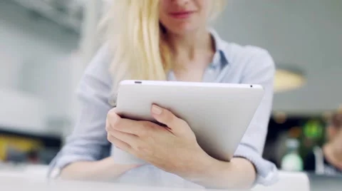 Girl With a Tablet in Hands Sitting on a Table Stock Footage 66250045