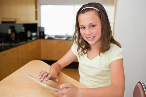 Girl with tablet at the kitchen table Foto stock
