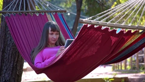 Girl with tablet pc on hammock Stock Footage 72921439