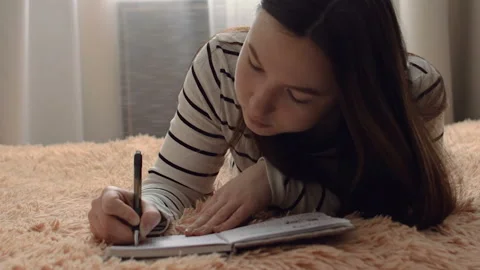 The girl takes notes in a notebook. Stockbeeldmateriaal 104085078