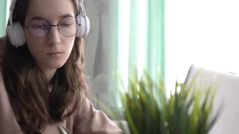 A girl takes notes in a notebook from her laptop. Stock Footage 172258919
