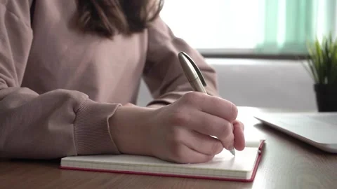 A girl takes notes in a notebook from her laptop. Stock Footage 178984523