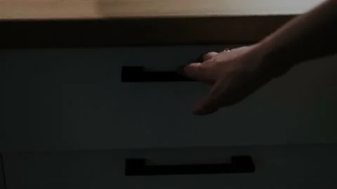 The girl takes out a knife with a wooden handle from a white kitchen drawer. Stock Footage