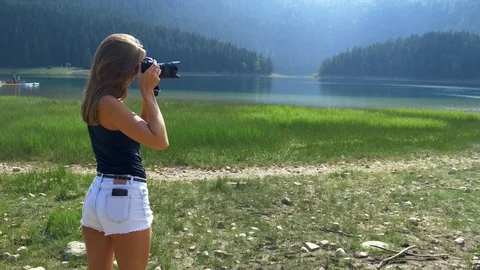 Girl takes picture stands against footage