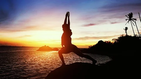 A girl takes a pose, while training on a sunset background. slow motion Video stock 105146545