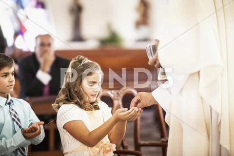 Girl taking her first communion at church Stock-Fotos