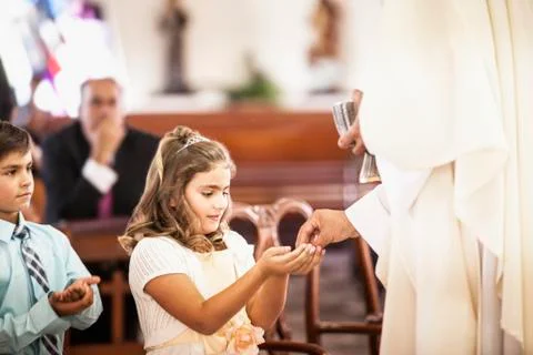 Girl taking her first communion at church Stock Photos