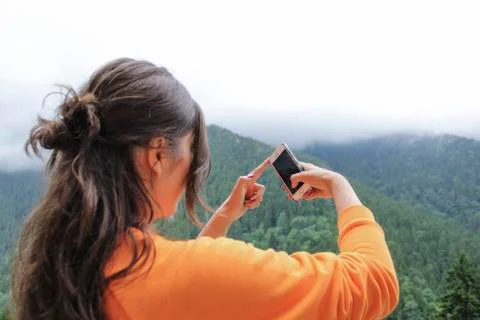 Girl taking nature photo by phone Stock Photos