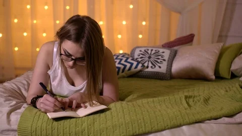 Girl taking notes on a bed Stock Footage 74645262