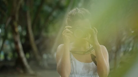 Girl taking photo on the ocean coast with film camera with nikon slr Stock Footage