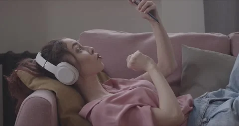 Girl taking a selfie while lying on the couch Stock Footage 154337323