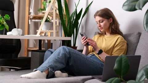 Girl talking on the phone while sitting on the sofa surrounded Stock Footage 274500060
