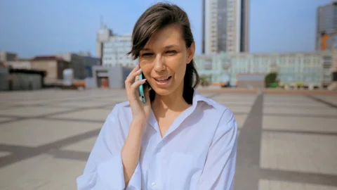 Girl talking on phone while standing in street Stock Footage 111749577