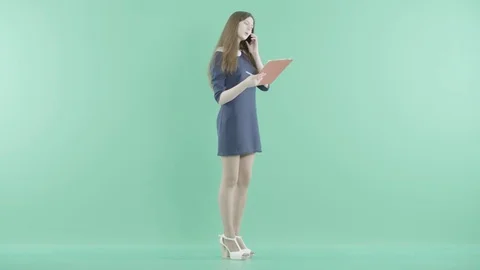 A girl talks on the phone with the clipboard in hands Stock Footage
