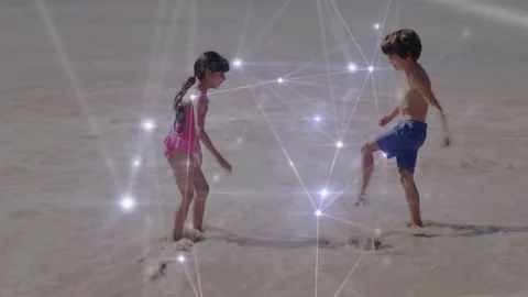 Girl tapping sand causing bright flare, boy mirroring kicks, tech overlay Stock Footage 334182857