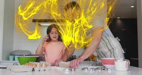Girl tapping tablet for cooking tutorial and guiding man rolling dough as yellow Video stock 317834114