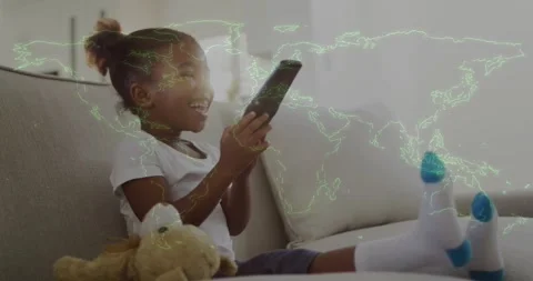 Girl tapping touchscreen, shifting on sofa, initiating green world-map animation Stock Footage 333965331