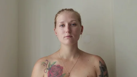 Girl with tattoos eats a cucumber. Video stock 119720443