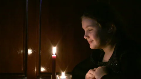 Girl the teenager looks at a burning candle. Stock Footage