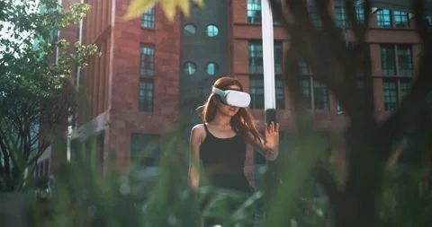 Girl testing virtual reality glasses in the city Stock Footage 201679368