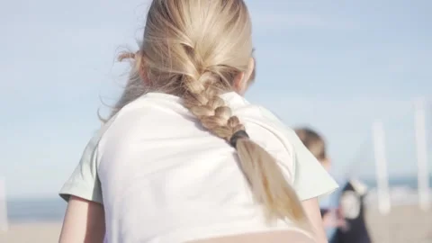 A girl with a thick long braid whispers in her friend's ear Stock Footage 265231442