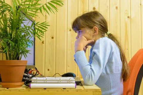 The girl thought hard while solving a problem in the computer Stock Photos