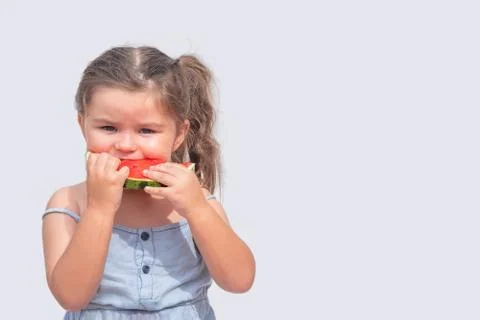 Girl three years old eats a red watermelon Stock Photos