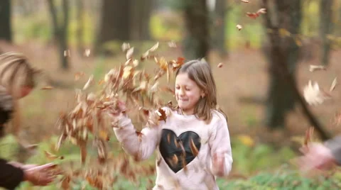 Girl throwing leaves on her parents Stock Footage 59554375