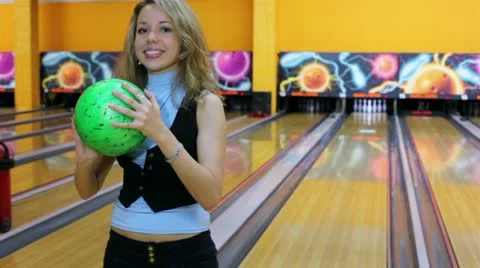Girl throws bowling ball to beat skittles, then jumps very happy Stock Footage