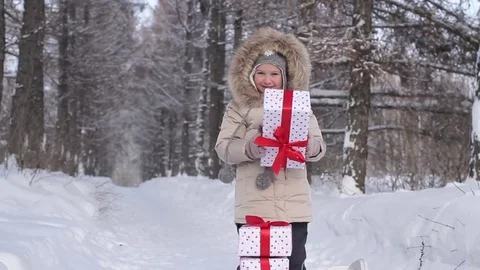 Girl Throws up a Box With a Gift in a Winter Forest Stock-Footage 71777487