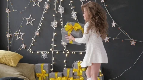 Girl throws a Christmas present on a background of Christmas decorations Vidéo 85130903