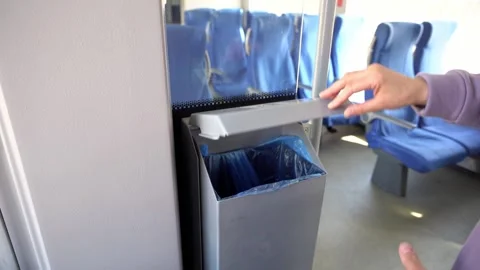 Girl throws garbage into a trash can on public transport Stock Footage 242604987