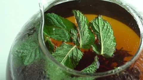 Girl throws mint leaves in a tea Video stock 69780689