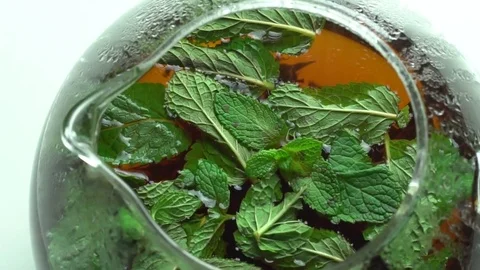 Girl throws mint leaves in a tea Stock Footage 69780752