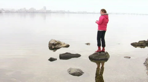 Girl throws a pebble in river Stock Footage 352104