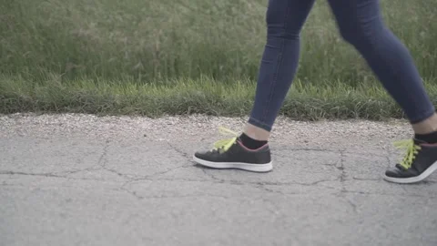 The girl throws a plastic cup to the ground. Close-up of walking legs agains Stock Footage 242091284