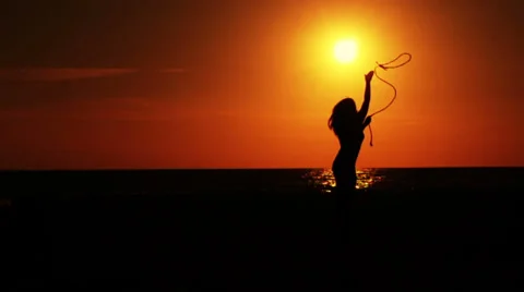 Girl throws a rope to the sun at sunset (Silhouette) Stock-Footage 33648070